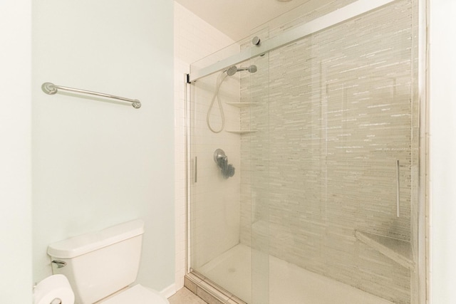 bathroom with a shower stall and toilet