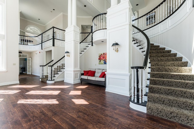 entrance foyer with baseboards, decorative columns, stairway, and dark wood-style flooring