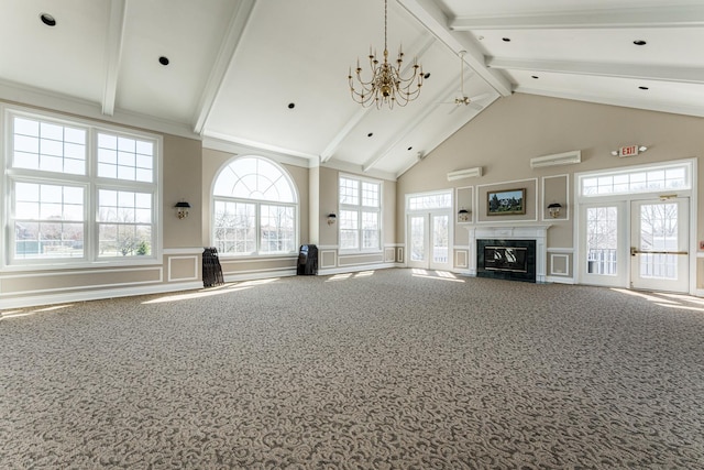 unfurnished living room featuring a premium fireplace, beamed ceiling, an inviting chandelier, carpet floors, and a decorative wall