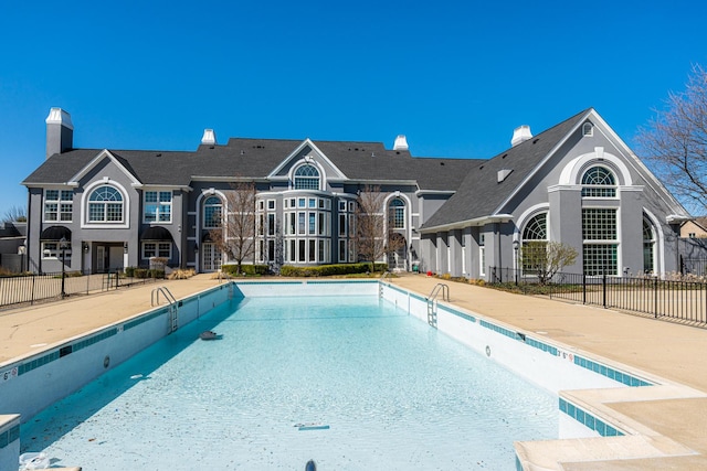 pool with a patio and fence