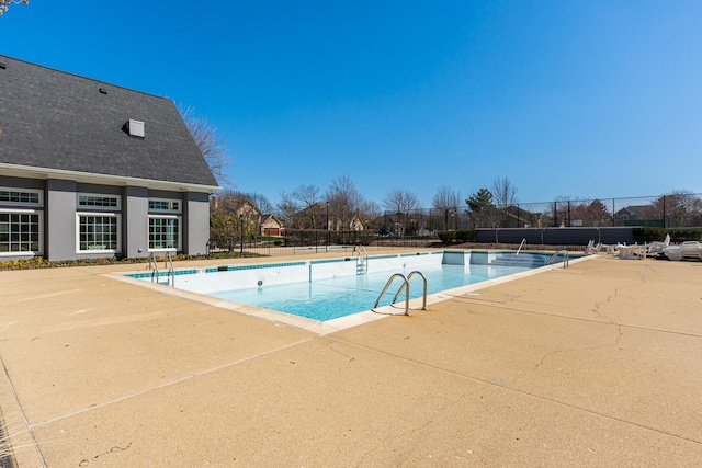 community pool with fence and a patio