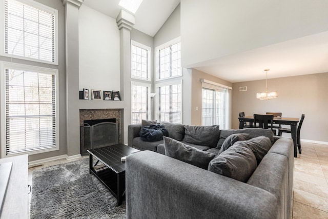 living room featuring a fireplace, light tile patterned floors, visible vents, high vaulted ceiling, and baseboards