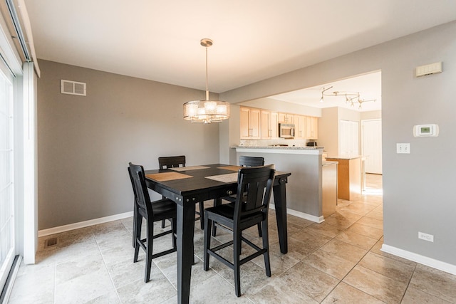 dining area featuring light tile patterned floors, baseboards, visible vents, and a chandelier