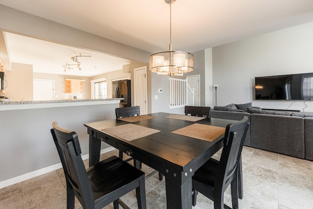 dining room featuring an inviting chandelier and baseboards