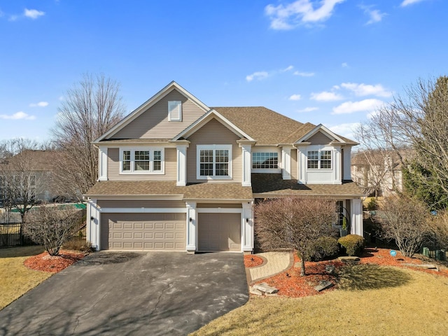 view of front of property with a shingled roof, driveway, an attached garage, and fence