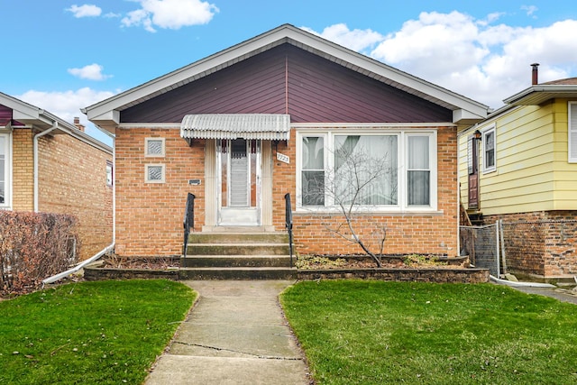 bungalow-style house with a front yard, brick siding, and fence