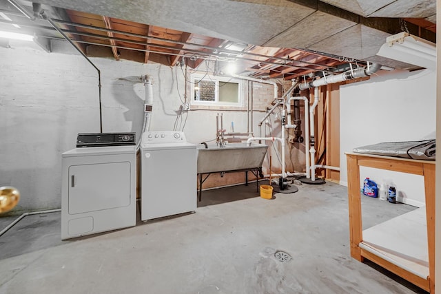 unfinished basement with a sink and washing machine and clothes dryer