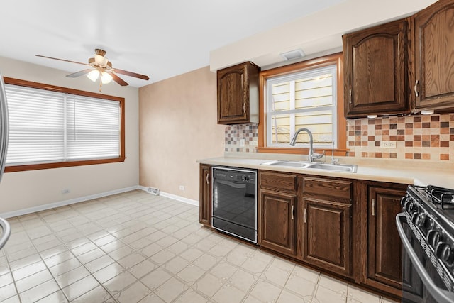 kitchen with black dishwasher, gas range, a sink, light countertops, and a wealth of natural light