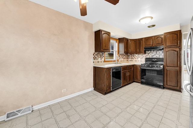 kitchen featuring light floors, visible vents, a sink, under cabinet range hood, and black appliances