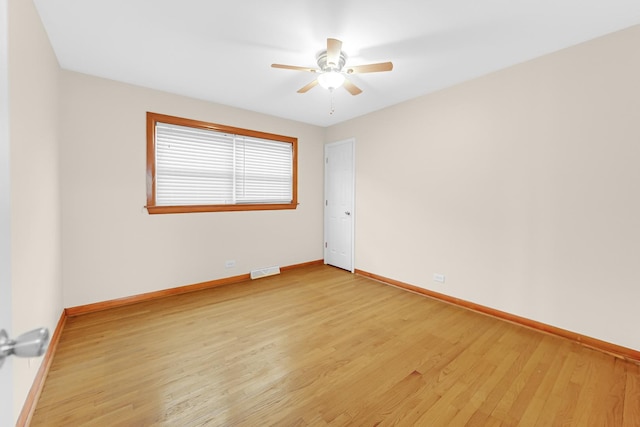 unfurnished room featuring baseboards, visible vents, ceiling fan, and light wood finished floors