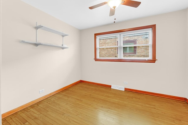 spare room featuring ceiling fan, light wood-type flooring, visible vents, and baseboards