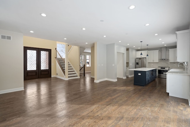 kitchen featuring a center island, french doors, stainless steel appliances, visible vents, and open floor plan