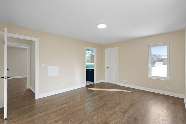 spare room featuring dark wood finished floors and baseboards