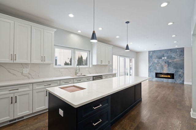 kitchen with white cabinets, dark cabinetry, dark wood-style flooring, and a sink