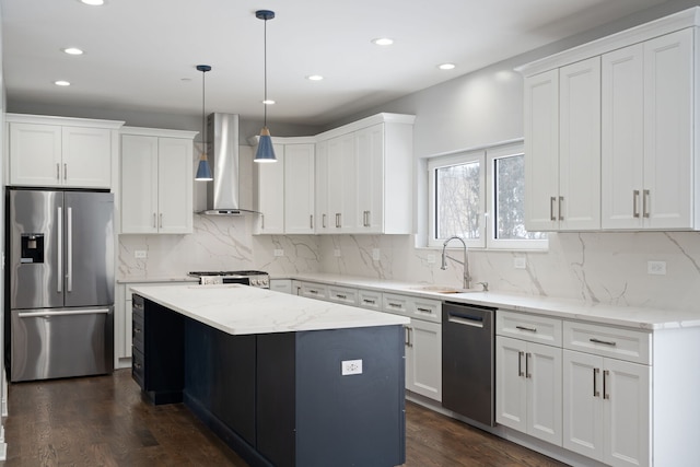 kitchen with stainless steel appliances, dark wood-type flooring, a kitchen island, a sink, and wall chimney exhaust hood