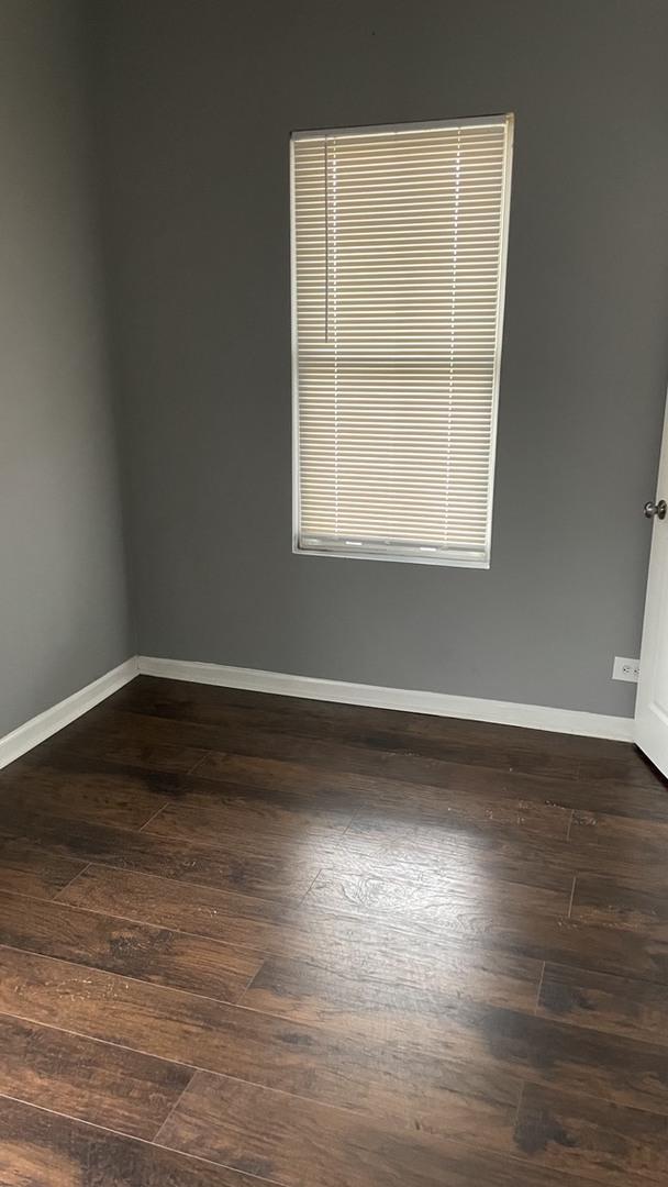 unfurnished room with dark wood finished floors and baseboards