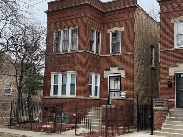 view of front facade featuring a gate, brick siding, and a fenced front yard