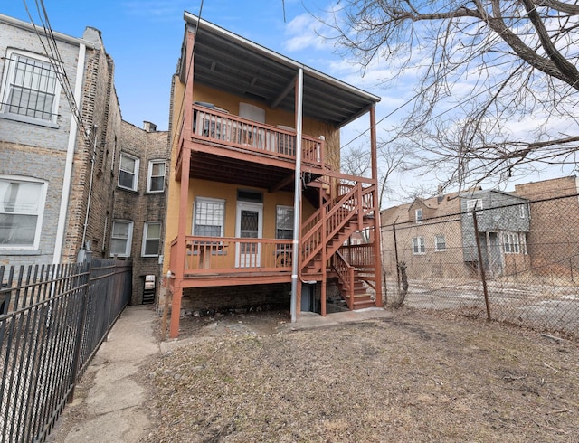 rear view of house featuring fence private yard and a balcony