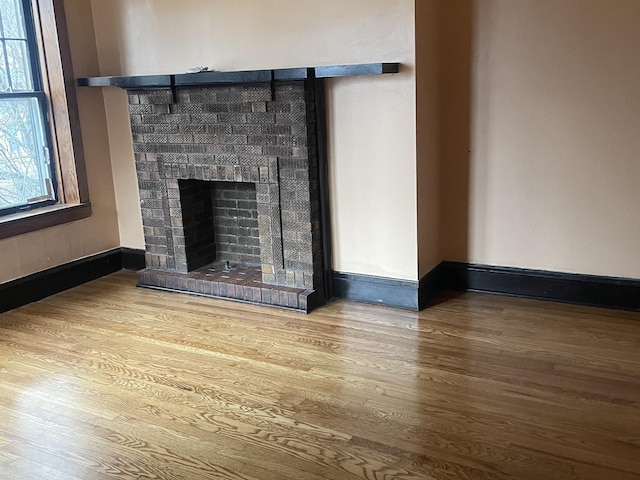 interior details with a fireplace, wood finished floors, and baseboards