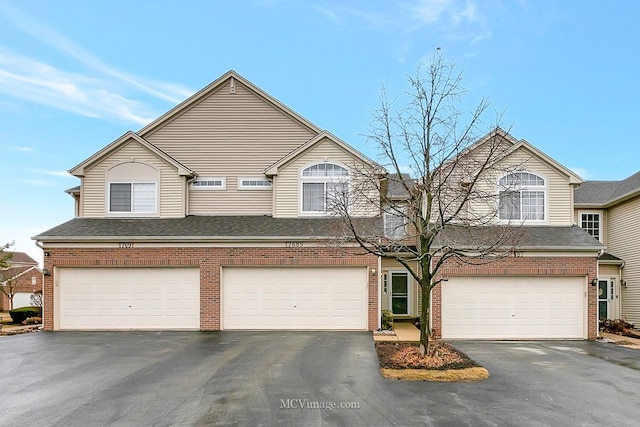 view of front of house with brick siding, driveway, and an attached garage