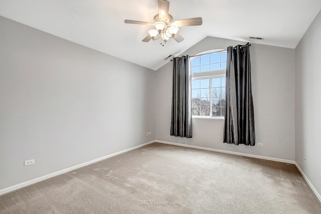 spare room with light carpet, lofted ceiling, visible vents, and baseboards