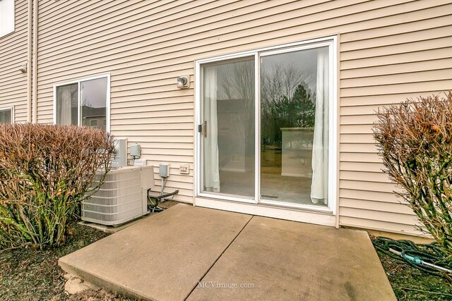 doorway to property featuring central air condition unit and a patio area