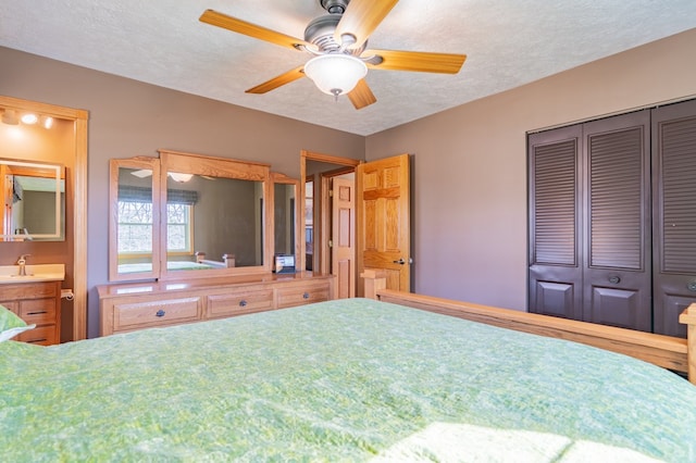 unfurnished bedroom with ensuite bath, ceiling fan, a sink, a closet, and a textured ceiling