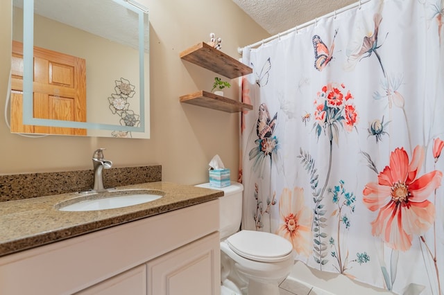 bathroom featuring a textured ceiling, vanity, and toilet