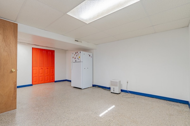 spare room featuring visible vents, speckled floor, a paneled ceiling, and baseboards