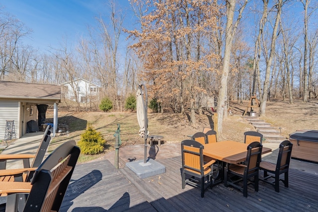 deck with outdoor dining space and a hot tub