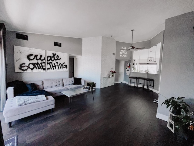 living room featuring a ceiling fan, baseboards, and dark wood-type flooring