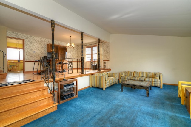 carpeted living room with a notable chandelier, wallpapered walls, and baseboards