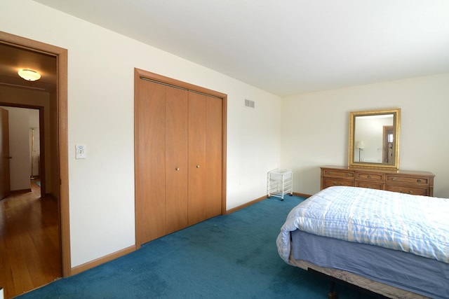 bedroom featuring a closet, visible vents, carpet flooring, and baseboards