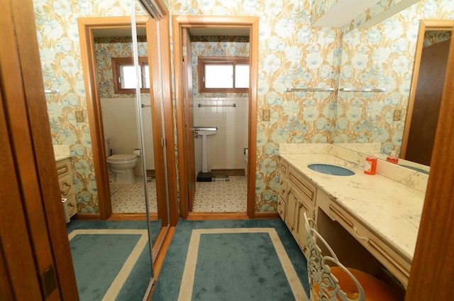 bathroom featuring wallpapered walls, toilet, and vanity