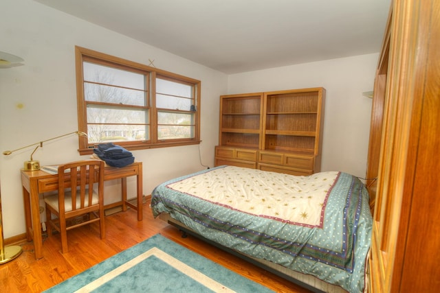 bedroom with baseboards and wood finished floors