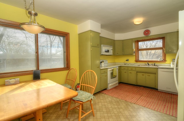 kitchen featuring green cabinets, light floors, light countertops, white appliances, and a sink