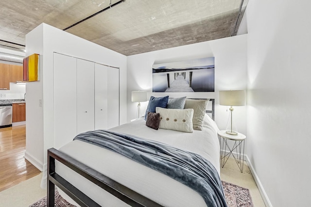 bedroom featuring a closet, baseboards, and light wood-style floors