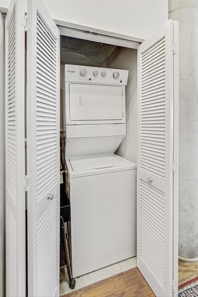 laundry room featuring light wood-style floors, stacked washer and dryer, and laundry area