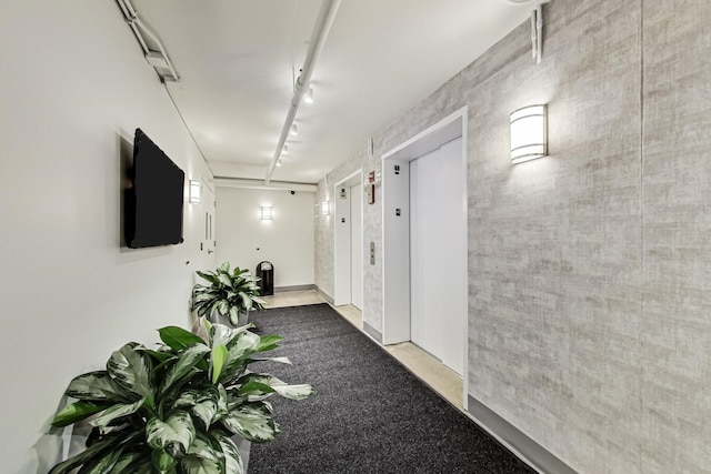 hall featuring elevator and track lighting