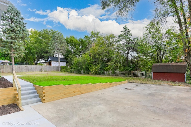 view of patio / terrace featuring fence private yard, a storage shed, and an outbuilding