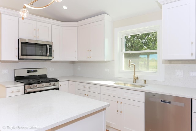 kitchen featuring tasteful backsplash, appliances with stainless steel finishes, white cabinetry, a sink, and recessed lighting