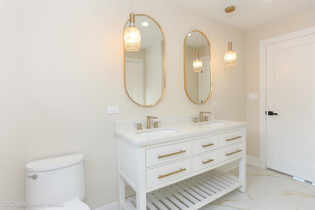 bathroom featuring double vanity, marble finish floor, toilet, and a sink