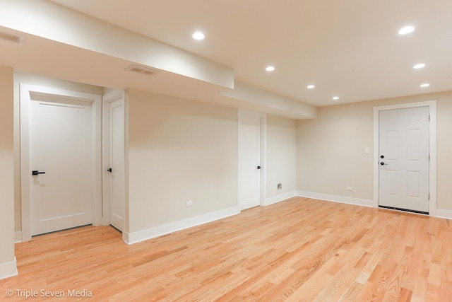 finished below grade area with baseboards, light wood-type flooring, visible vents, and recessed lighting