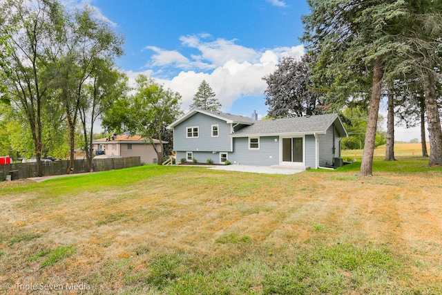 rear view of property with a lawn, a patio area, and fence