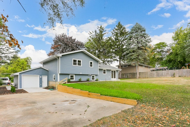 view of front of house with an attached garage, concrete driveway, a front yard, and fence