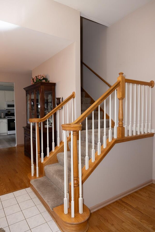 staircase featuring baseboards and wood finished floors