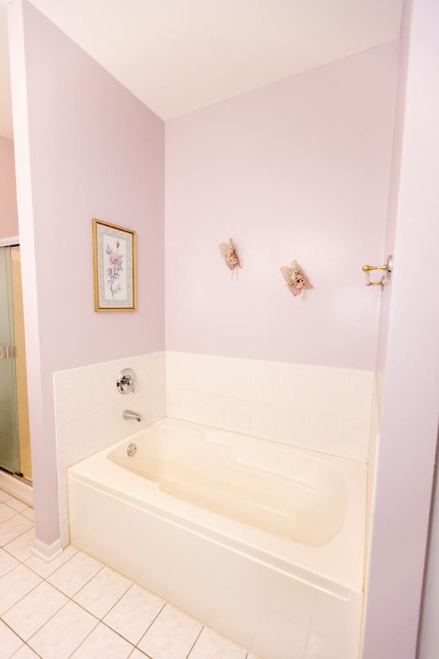 bathroom featuring tile patterned flooring, a bath, and a shower stall