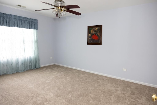 unfurnished room featuring baseboards, visible vents, ceiling fan, and carpet flooring