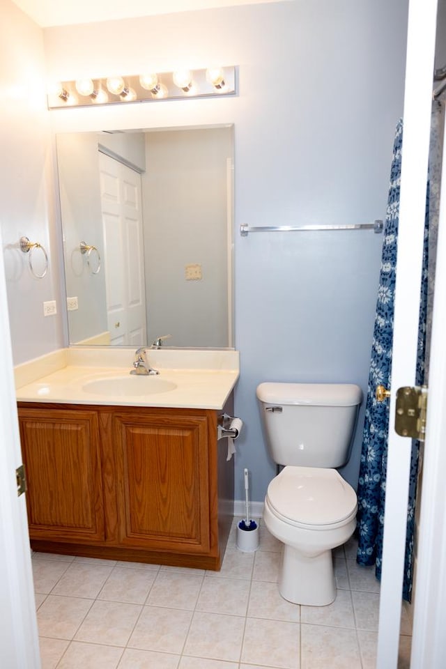 bathroom with toilet, vanity, and tile patterned floors