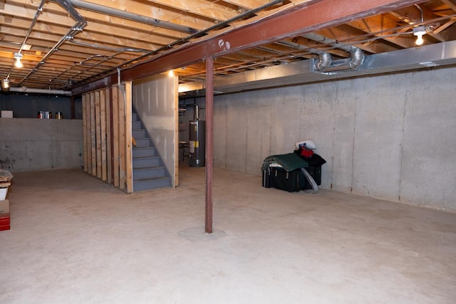 unfinished basement featuring water heater and stairs